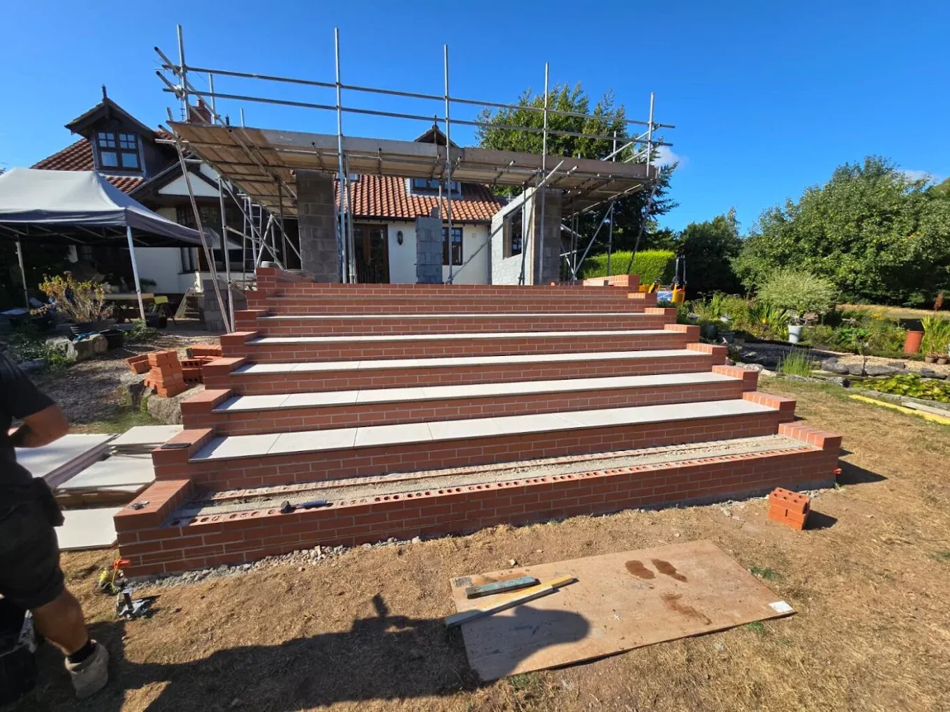Wide brick garden steps with scaffolding behind