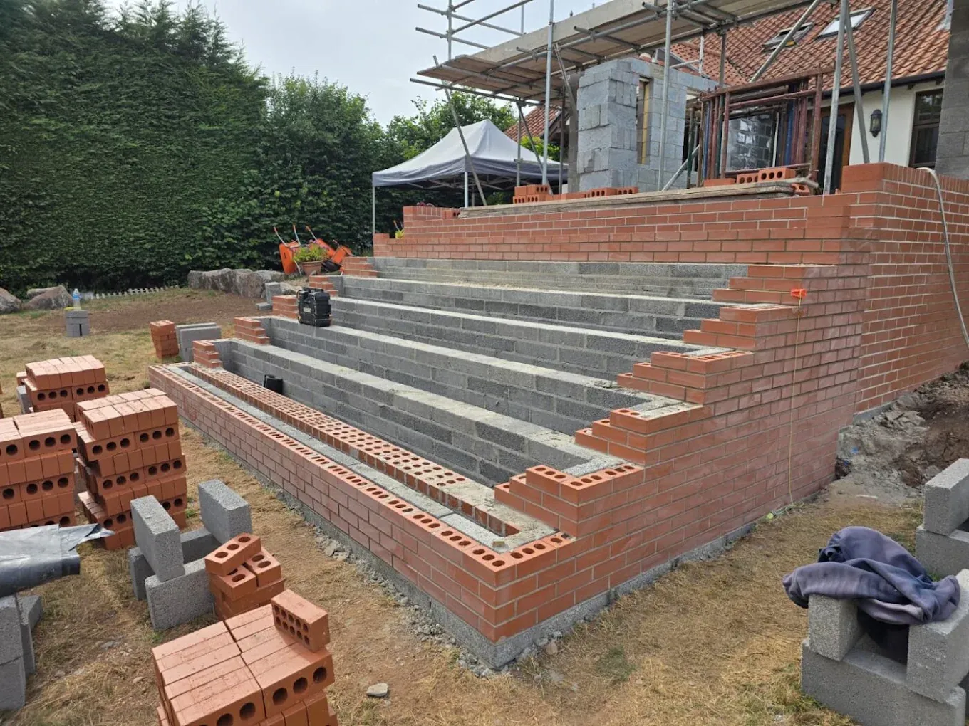 A brick garden terrace with bricks stacked ready to lay