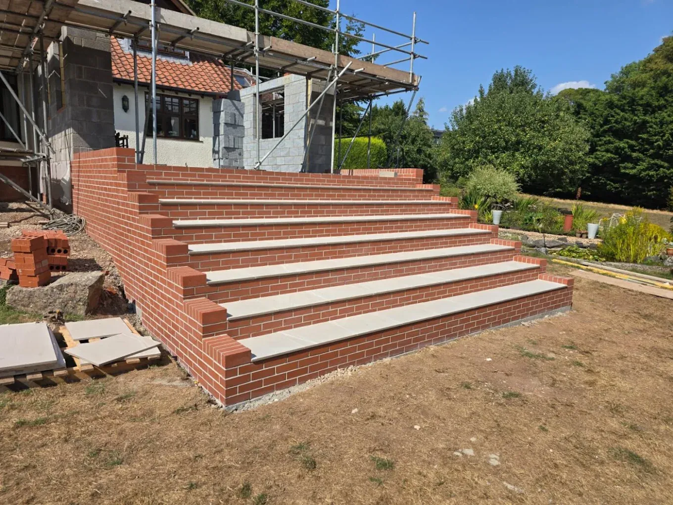Brick garden terracing with scaffolding behind