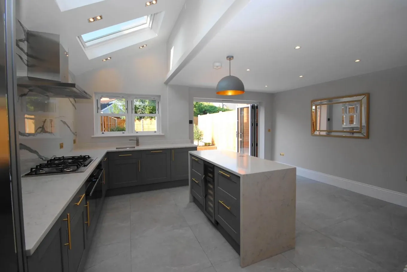 A dark grey kitchen lit by rooflights A dark grey kitchen lit by rooflights