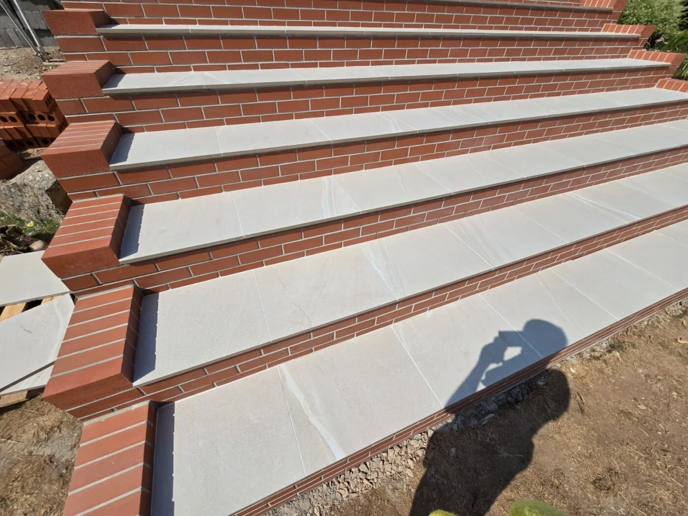 The finished entrance steps in red brick with wide pale porcelain treads The finished entrance steps in red brick with wide pale porcelain treads