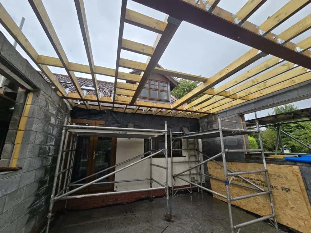 A glazed roof steel frame standing in scaffolding on the Farnham double storey extension A glazed roof steel frame standing in scaffolding on the Farnham double storey extension