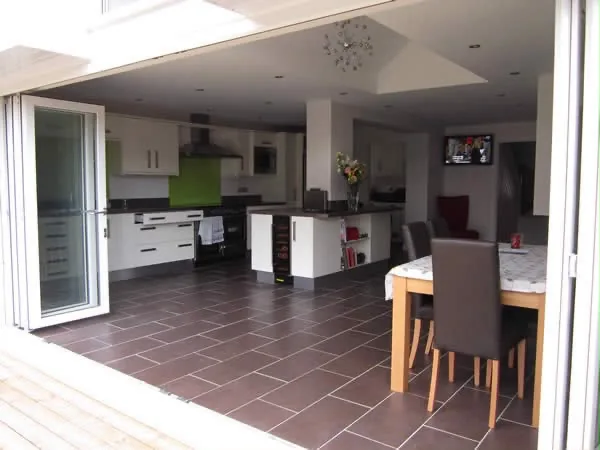 The finished kitchen and dining room seen from the open bifold doors