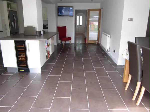 A finished tiled floor running from the kitchen back towards the front door