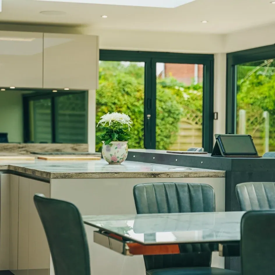 A kitchen island with bifold doors onto the garden A kitchen island with bifold doors onto the garden