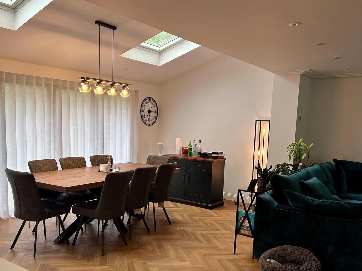 A dining table and seating area with two rooflights and herringbone flooring