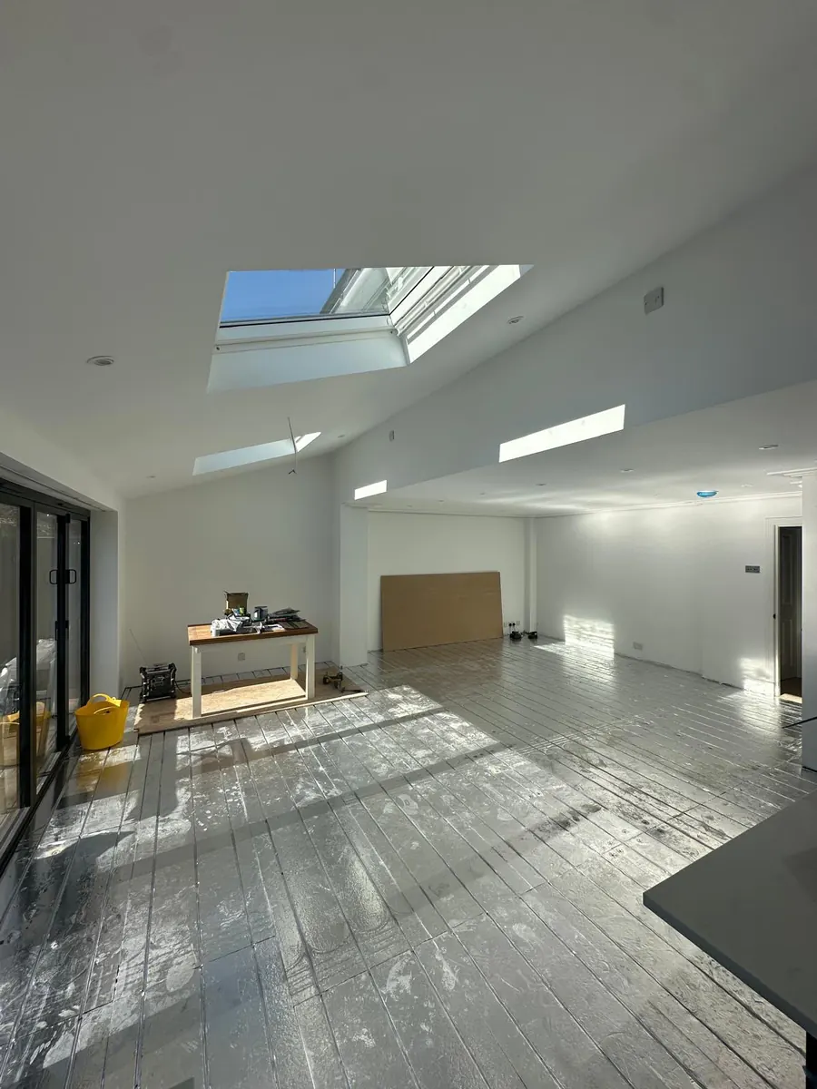 The finished extension shell painted white, with rooflights above and floor protection down