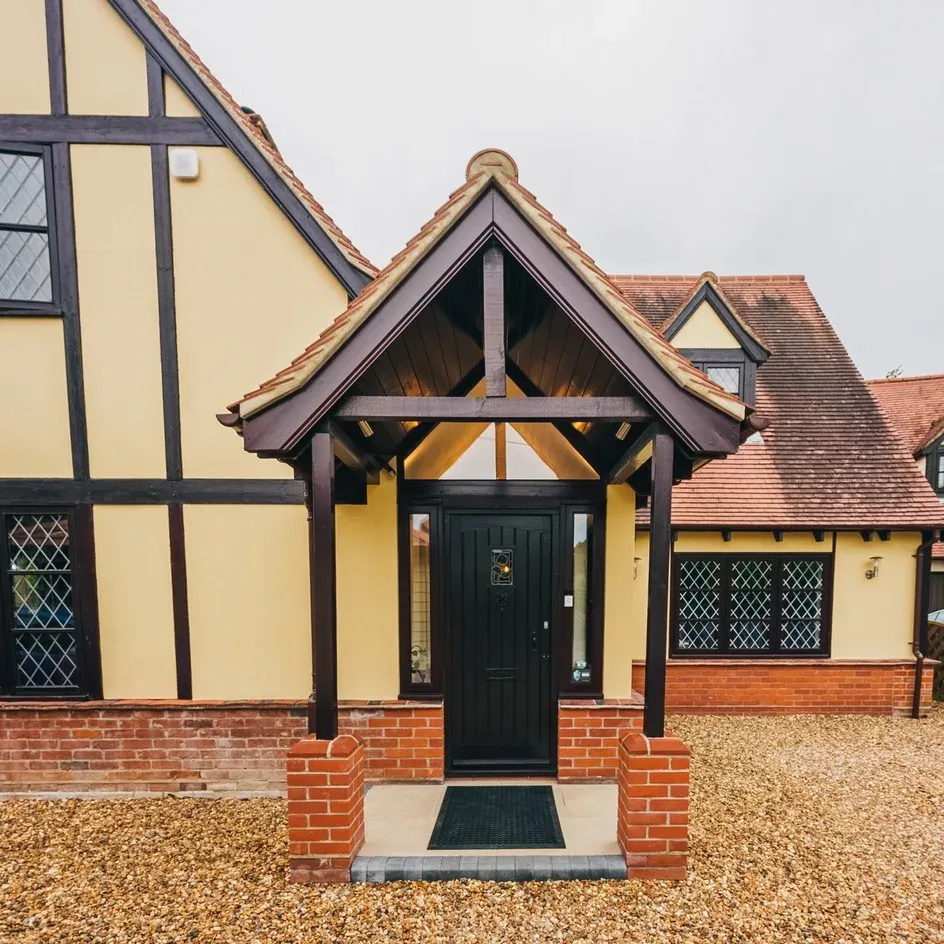 A mock-Tudor oak-framed porch with a black front door A mock-Tudor oak-framed porch with a black front door