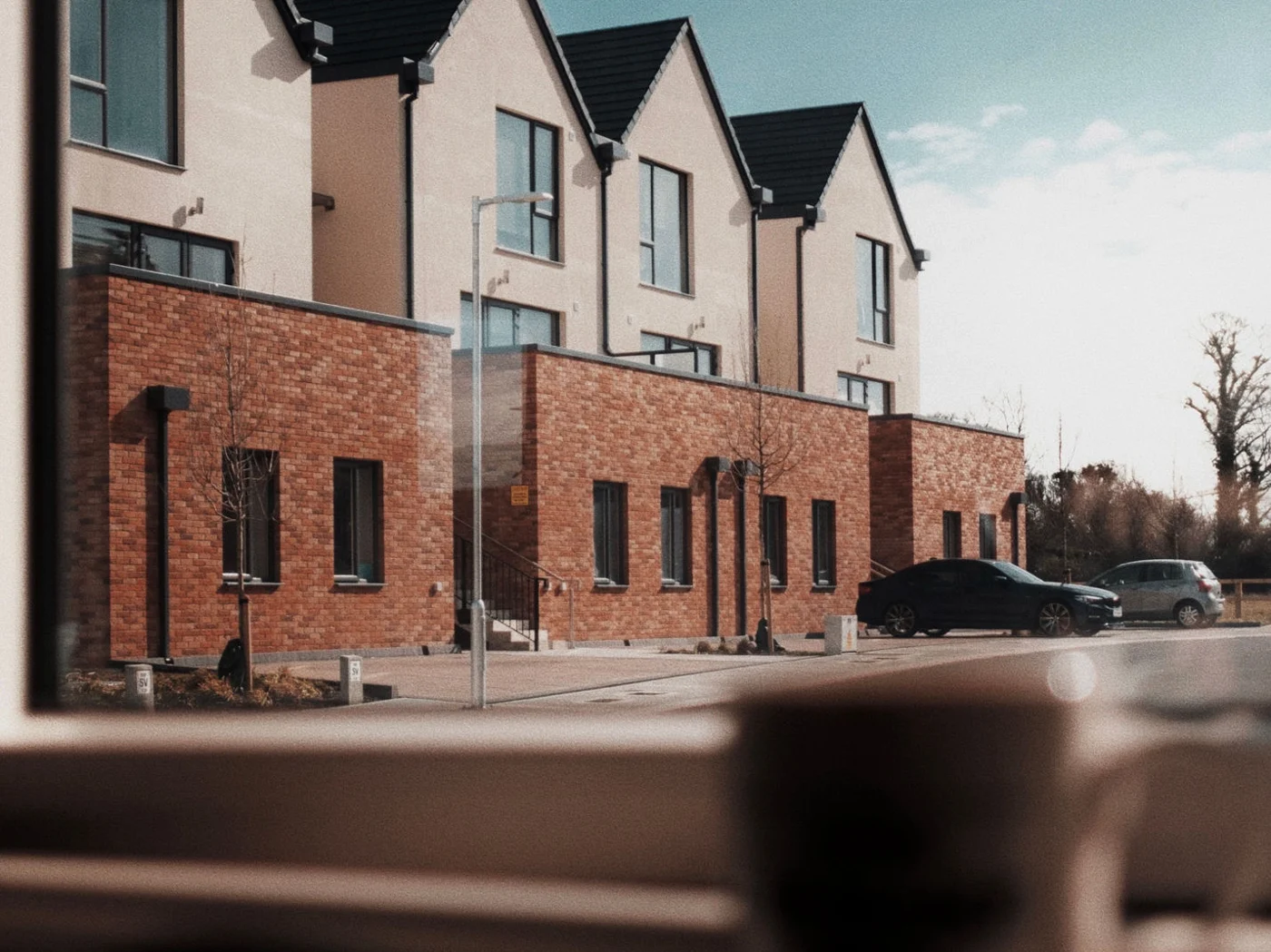 A terrace of newly built houses with rendered gables and brick ground floors A terrace of newly built houses with rendered gables and brick ground floors