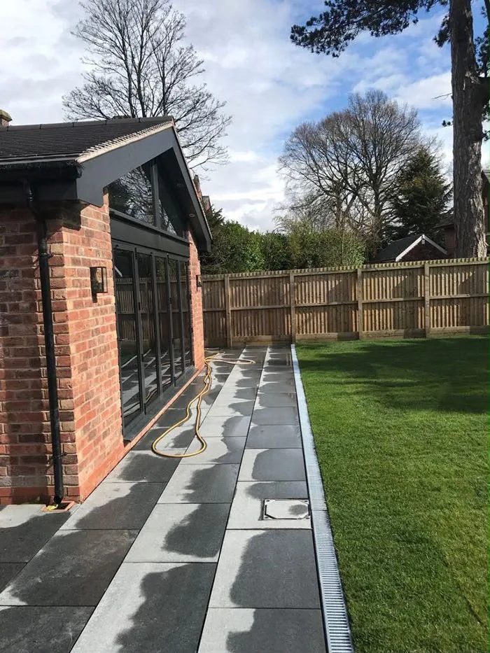 The finished glazed gable with bifold doors, granite paving and lawn